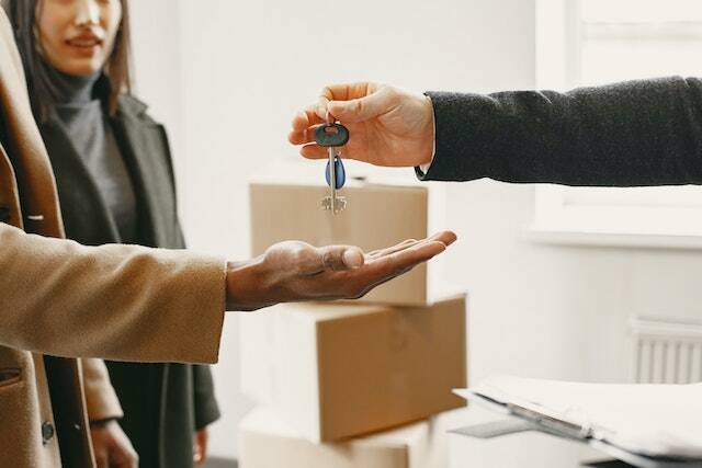 a landlord handing keys to new home to another person