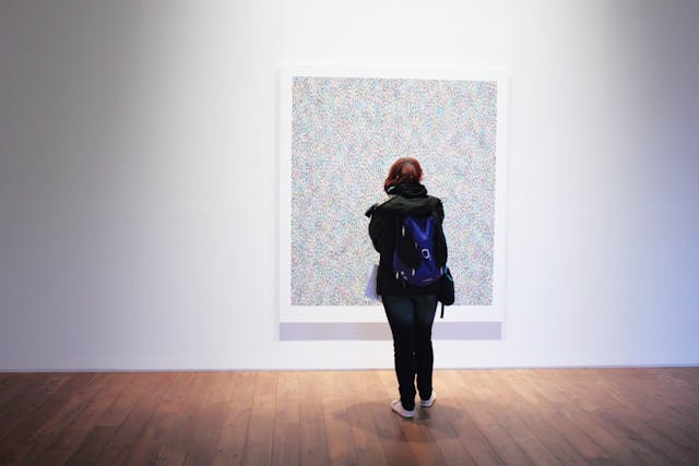 person-standing-infront-of-a-wall-mount-painting